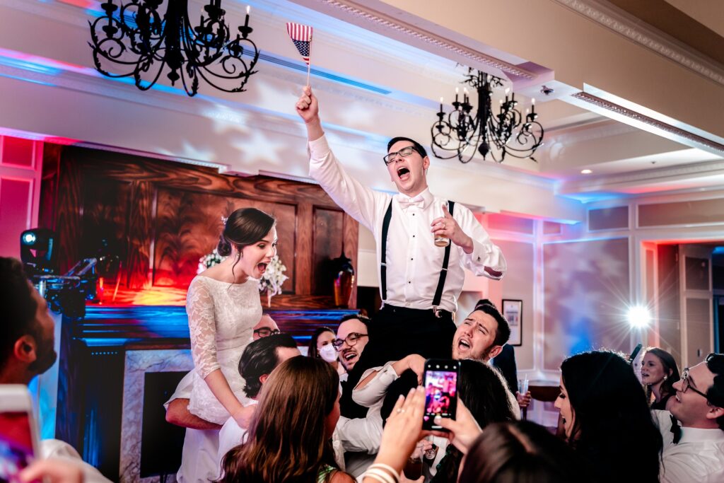 A bride and groom dancing and waving American flags at one of the best wedding venues in Fairfax County