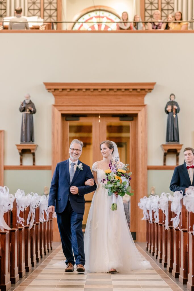 A bride and her father walking down the aisle at her St. Patrick Catholic Church wedding