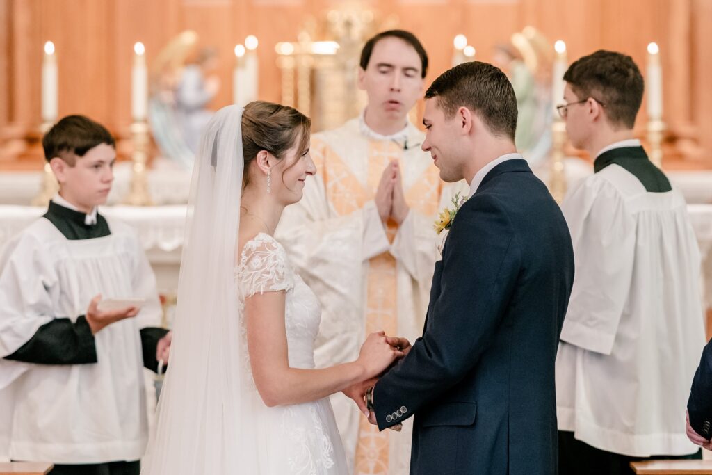 A bride and groom smile at each other during their Catholic wedding in Fredericksburg VA