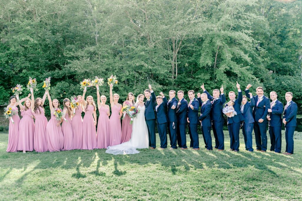 A large wedding party cheering for a Catholic wedding in Fredericksburg, VA