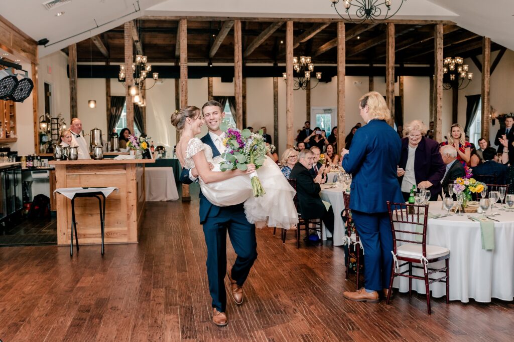 A groom carrying his bride into their Stevenson Ridge wedding reception