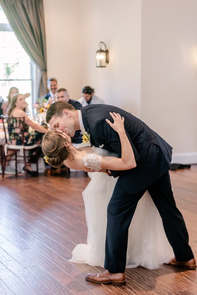 A groom dips his bride at the end of their first dance during their Catholic wedding in Fredericksburg VA