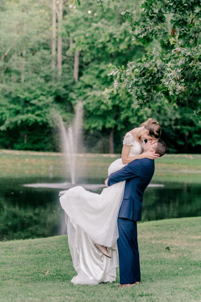 A groom lifting his bride as they nuzzle closely during their Stevenson Ridge wedding reception