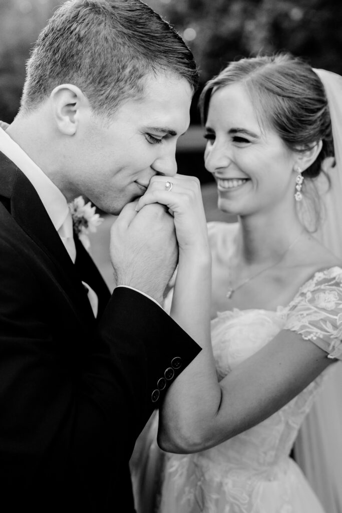 A groom kisses the hand of his bride during their Catholic wedding in Fredericksburg, VA