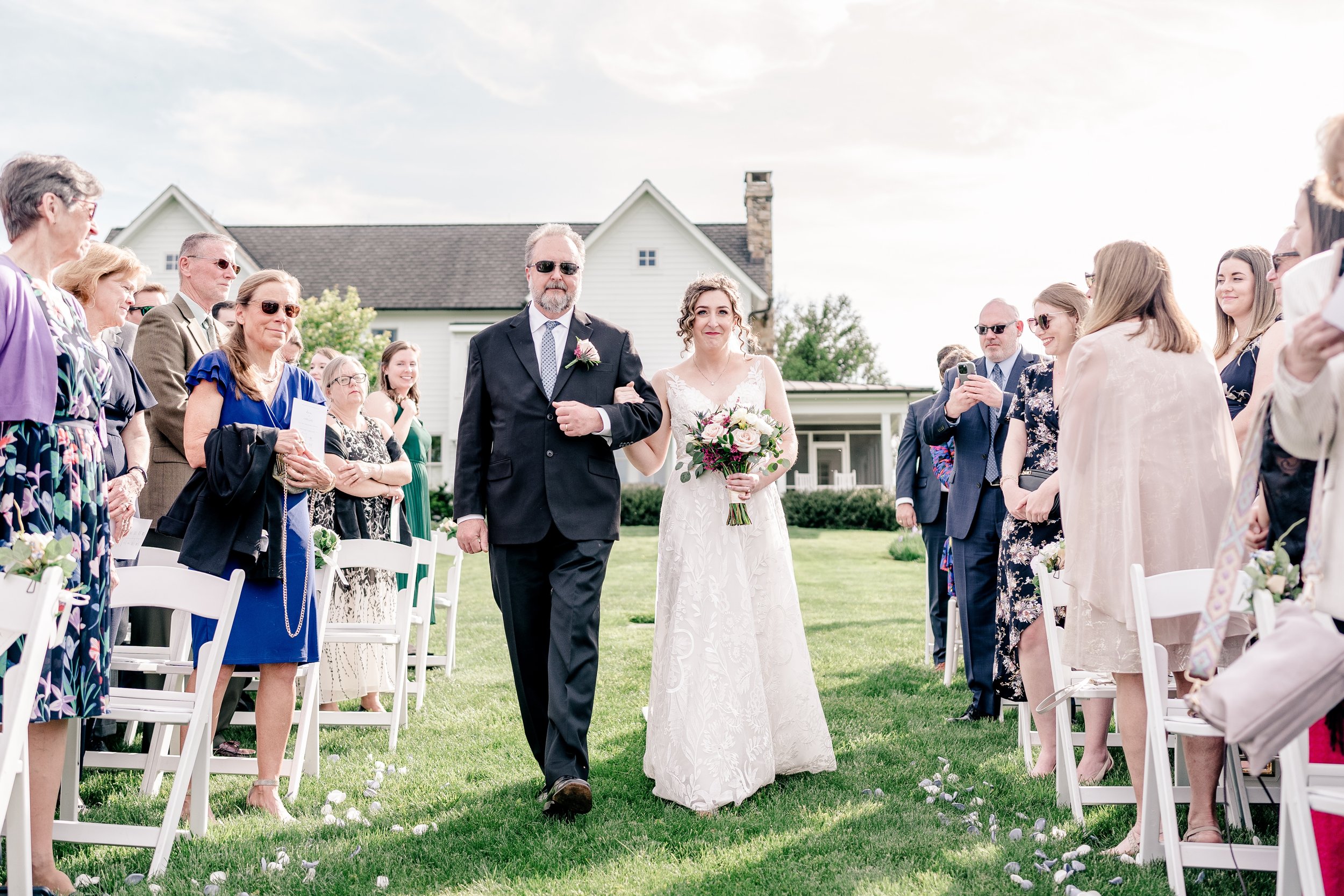 A bride walking down the aisle with her father during her wedding at Blue Hill Farm in Northern Virginia