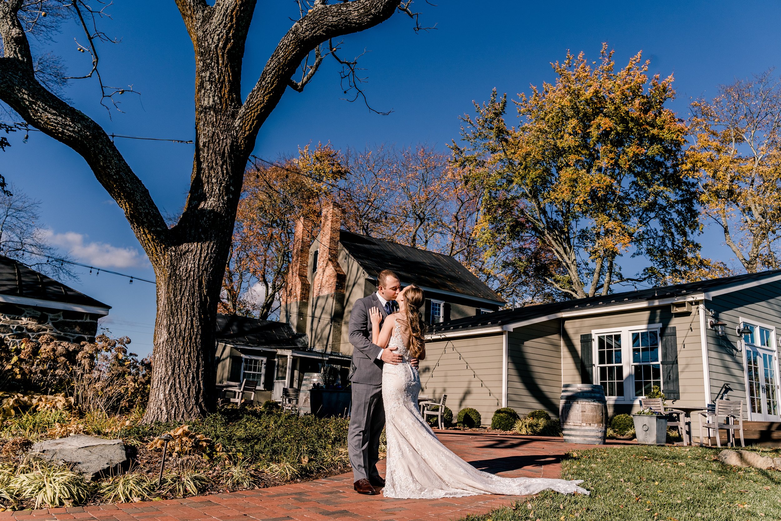 A bride and groom share a kiss in front of the tasting room at their best wedding venue in Loudoun County