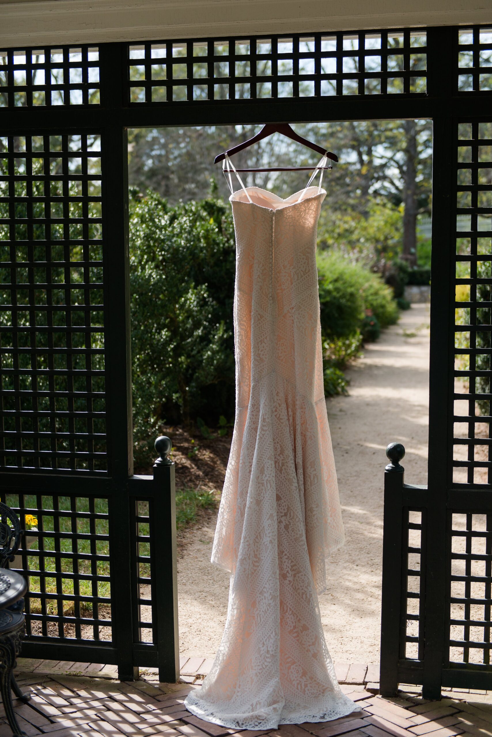 A wedding dress hanging in a romantic garden at one of the best wedding venues in Northern Virginia