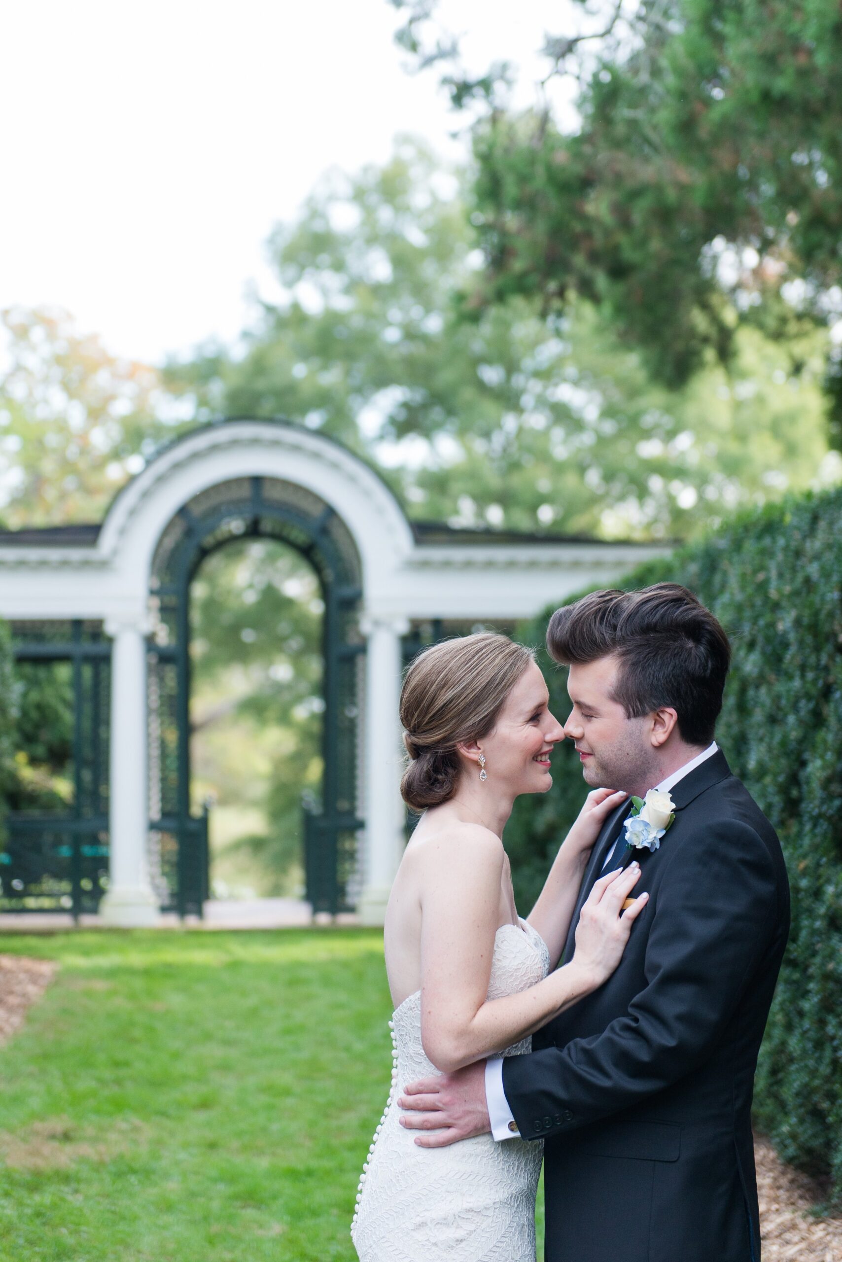 A bride and groom smiling at each other in a romantic garden before their wedding at Oatlands Historic House and Gardens in Loudoun County Virginia
