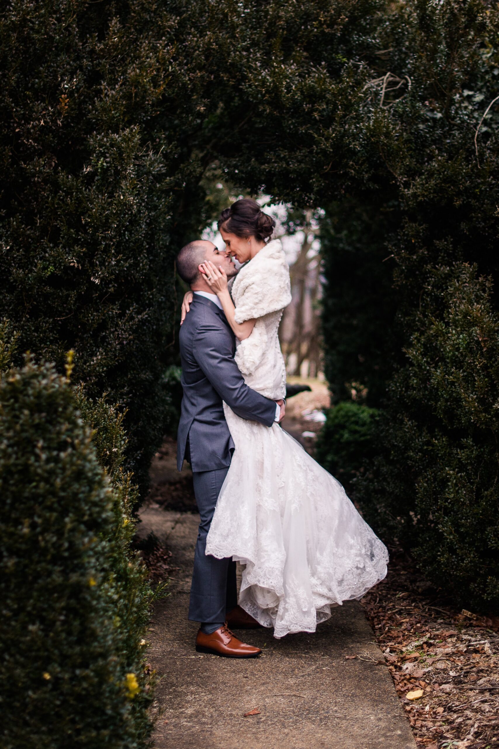 A bride and groom lean in for a kiss while in the gardens during their wedding at Raspberry Plain Manor in Loudoun County Virginia