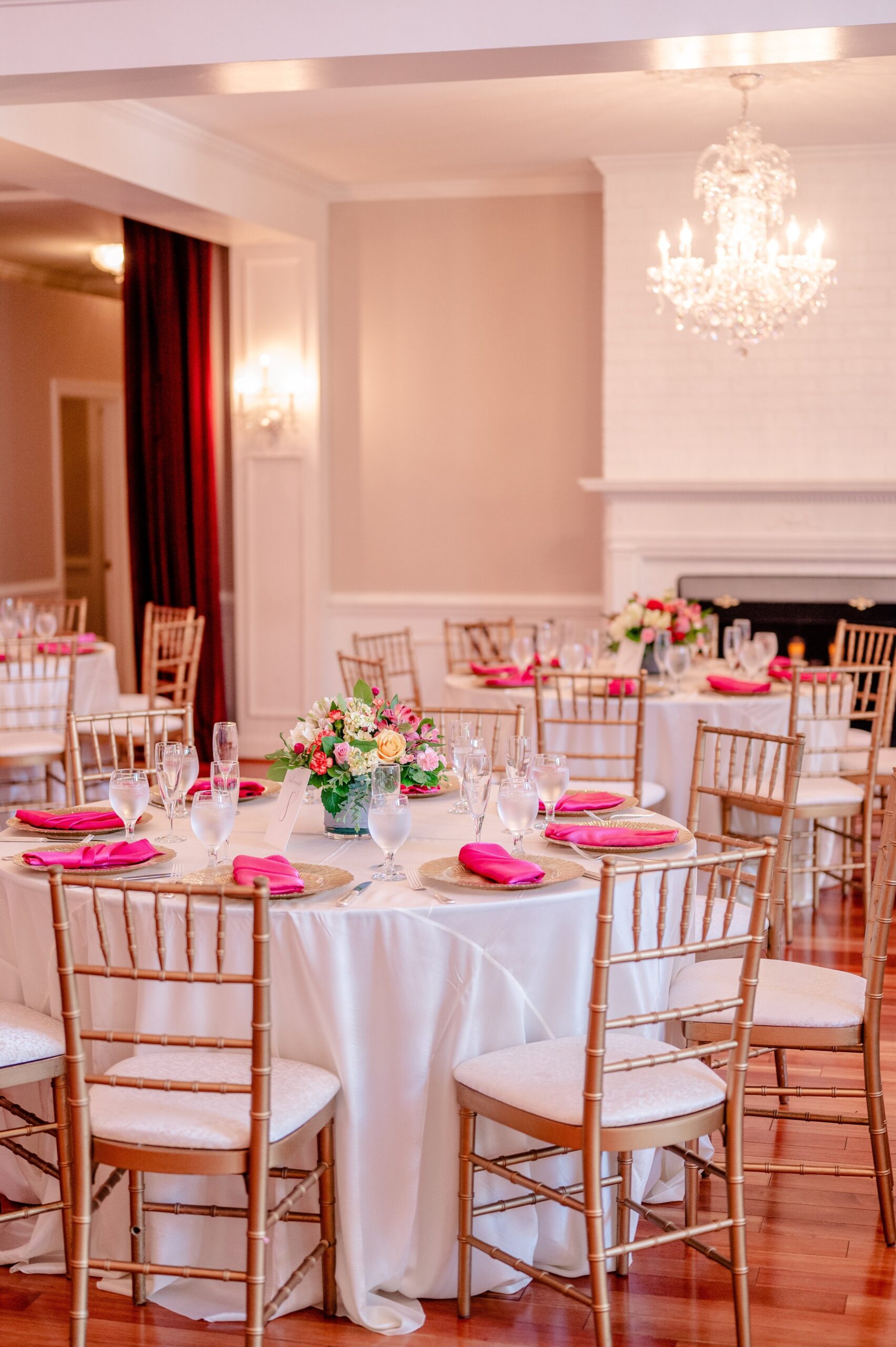 Dinner tables set with pink napkins and colorful floral arrangements at one of the best wedding venues in Loudoun County Virginia