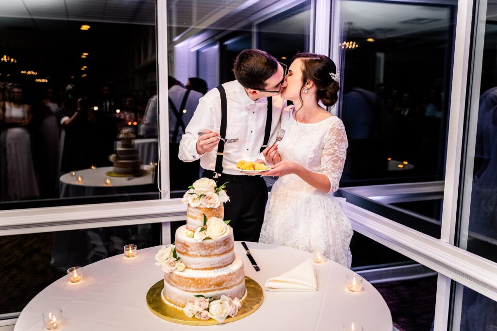 A bride and groom sharing a kiss during their cake cutting at one of the best wedding venues in Northern Virginia
