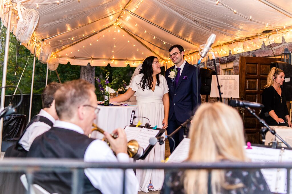 A bride and groom enjoying cocktail hour under a tent at Cabell's Mill