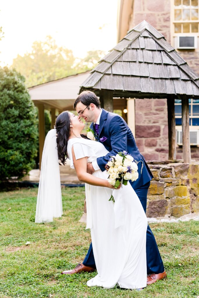 A bride and groom share a romantic moment in front of a stone well during their wedding at Cabell's Mill in Northern Virginia
