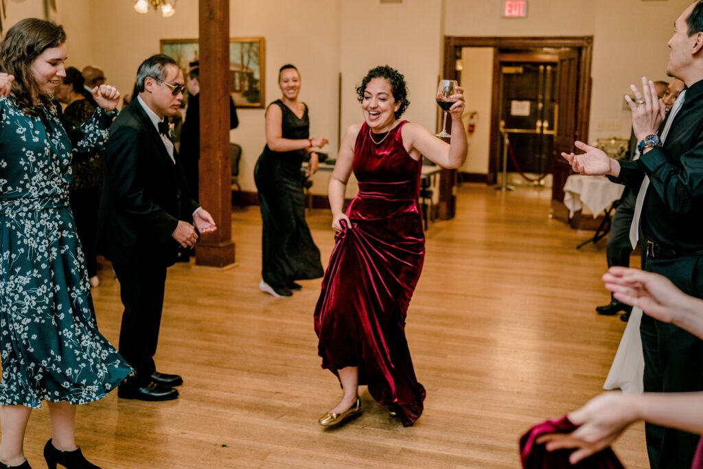 A wedding guest dancing with a glass of wine in Fairfax Virginia