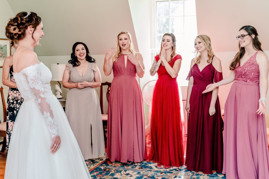 A group of bridesmaids reacting to seeing the bride during a wedding 