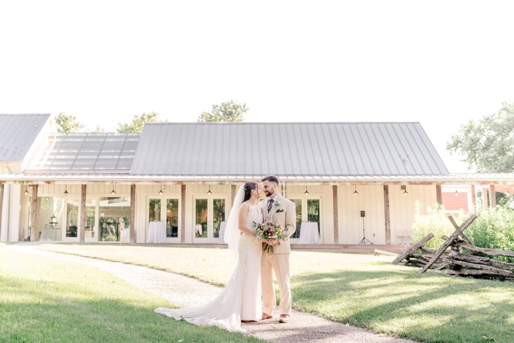 A bride and groom pose in front of the visitor center at one of the best wedding venues in Northern Virginia