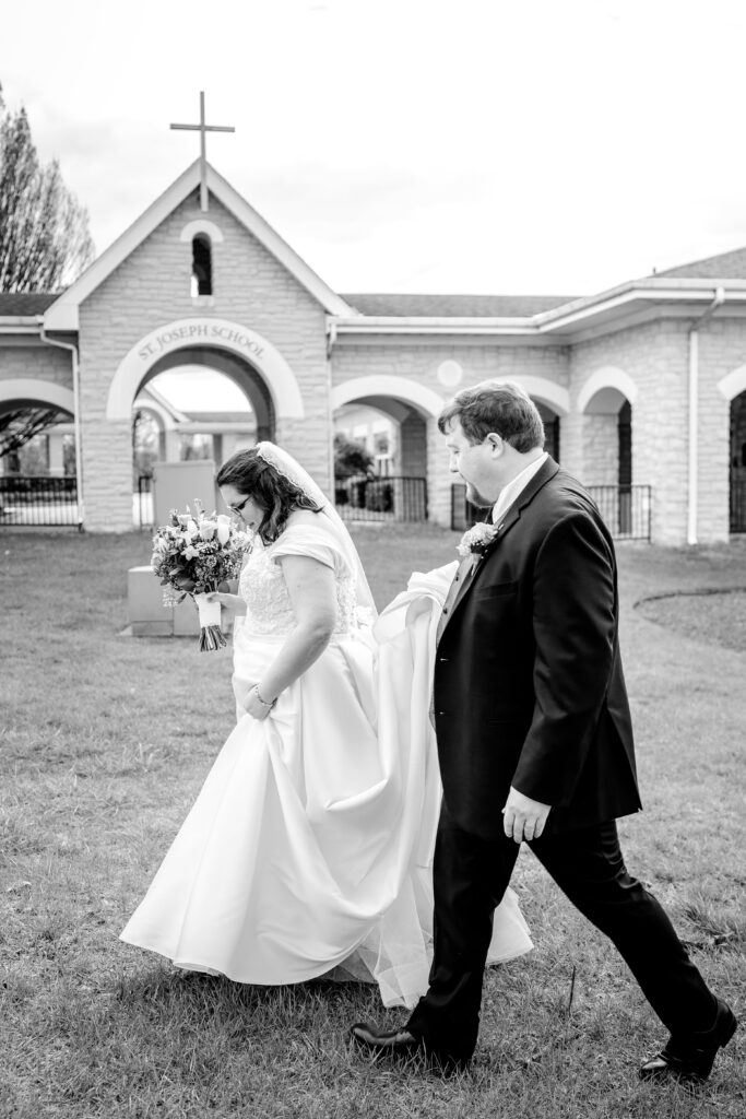A bride and groom walking together after their Catholic wedding at St. Joseph Church in Cockeysville, MD