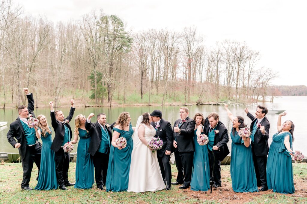 A wedding party cheers as the bride and groom share a kiss during their wedding near Baltimore MD