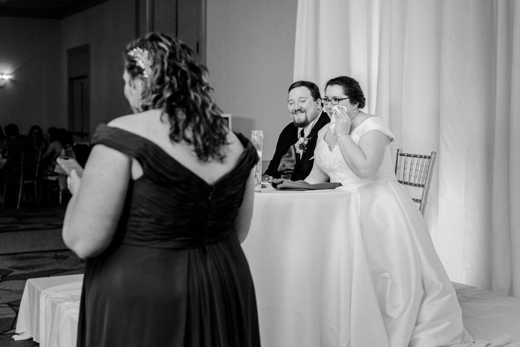 A bride wipes away tears during her Maid of Honor's toast during a Catholic wedding in Towson MD