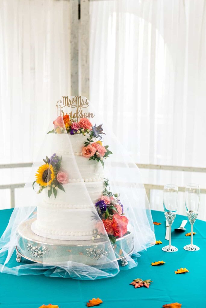 A buttercream cake decorated with a variety of colorful flowers for a wedding in Northern Virginia