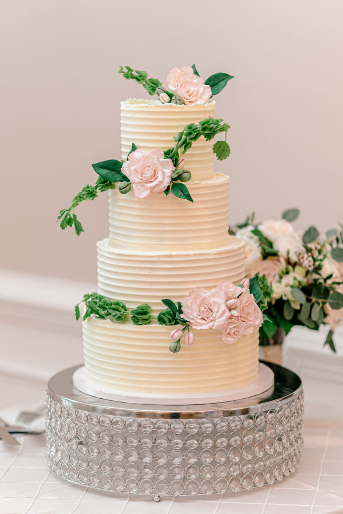 A simple buttercream wedding cake adorned with pink sugar flowers for a wedding in Northern Virginia