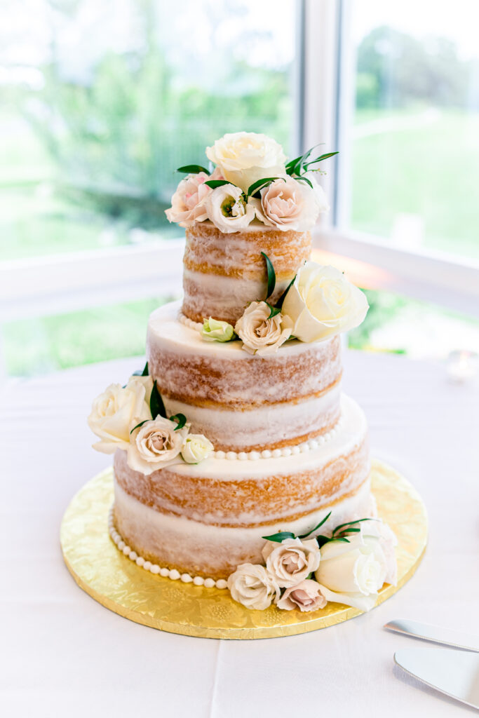 A naked cake decorated with cream colored roses for a wedding in Northern Virginia
