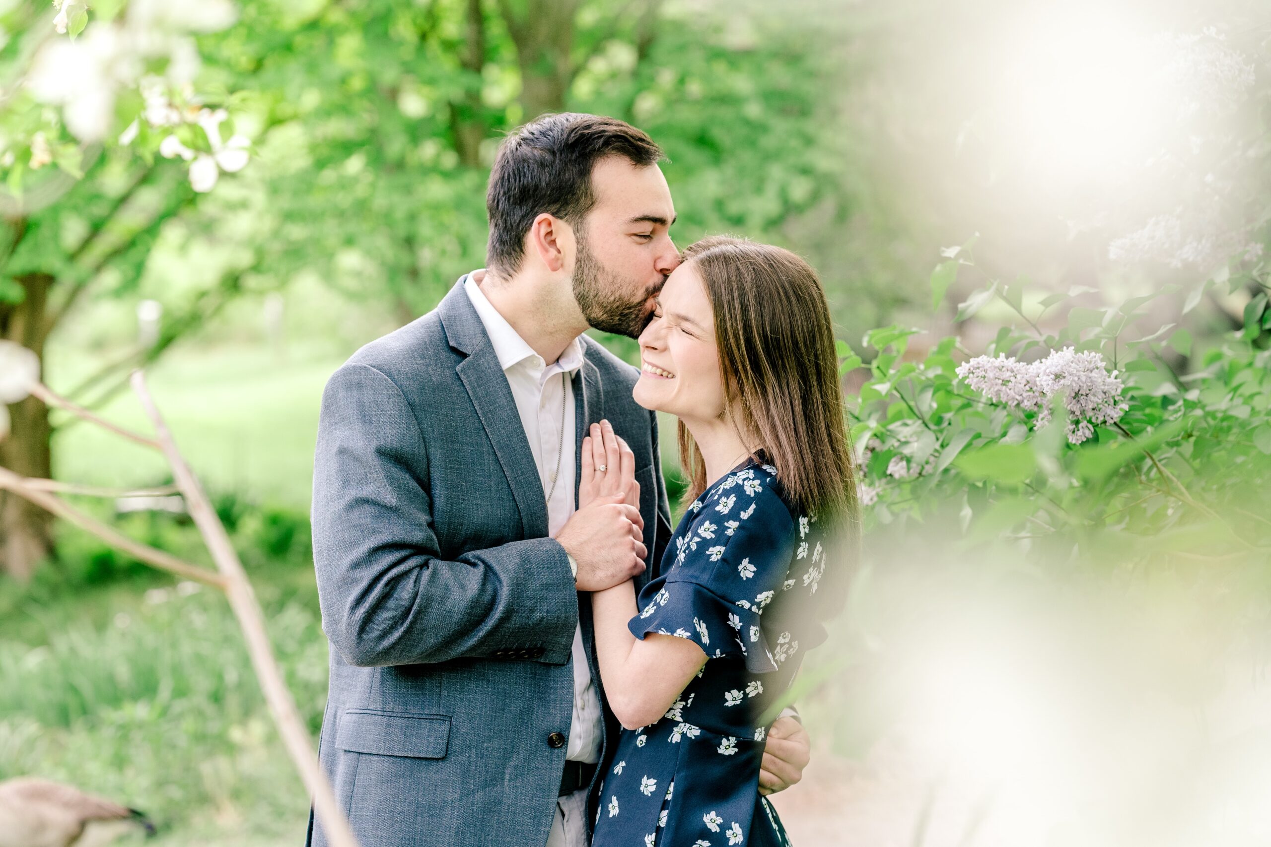 A man kisses his bride-to-be as she smiles during their Meadowlark Botanical Gardens engagement session