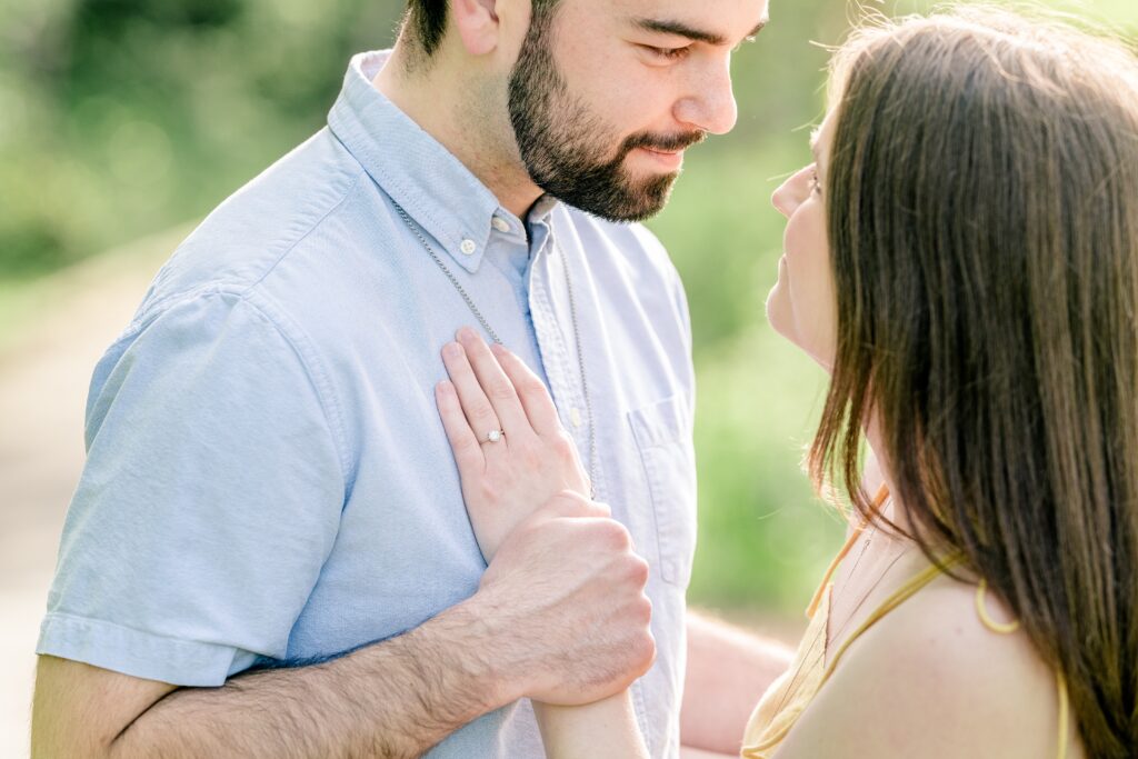 A couple gazes at one another as the camera focuses on her ring during their Meadowlark Botanical Gardens engagement session