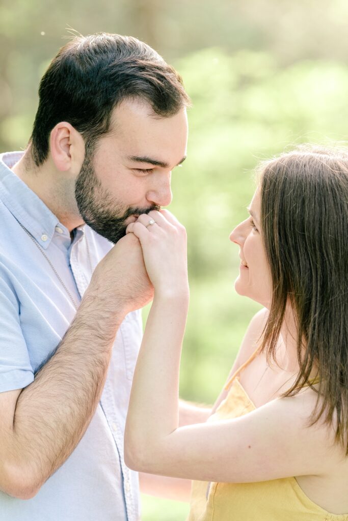 A man kisses the hand of his bride-to-be during their Meadowlark Botanical Gardens engagement session