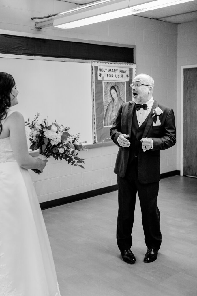 A father looking surprised during the father daughter first look before a wedding at St Philip Catholic Church in Falls Church Virginia