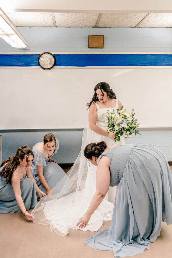 A bride preparing with her bridesmaids before a wedding at St Philip Catholic Church in Falls Church Virginia