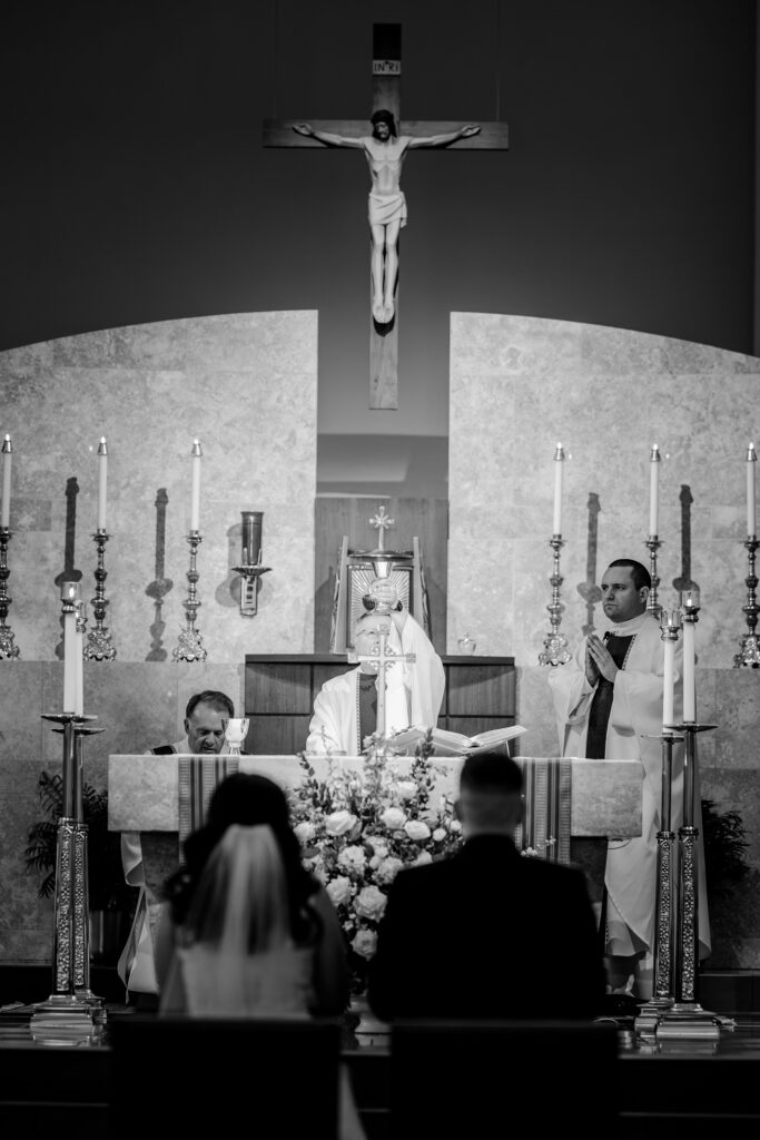 The priest raising the chalice during the Consecration for a wedding at St Philip Catholic Church in Falls Church Virginia