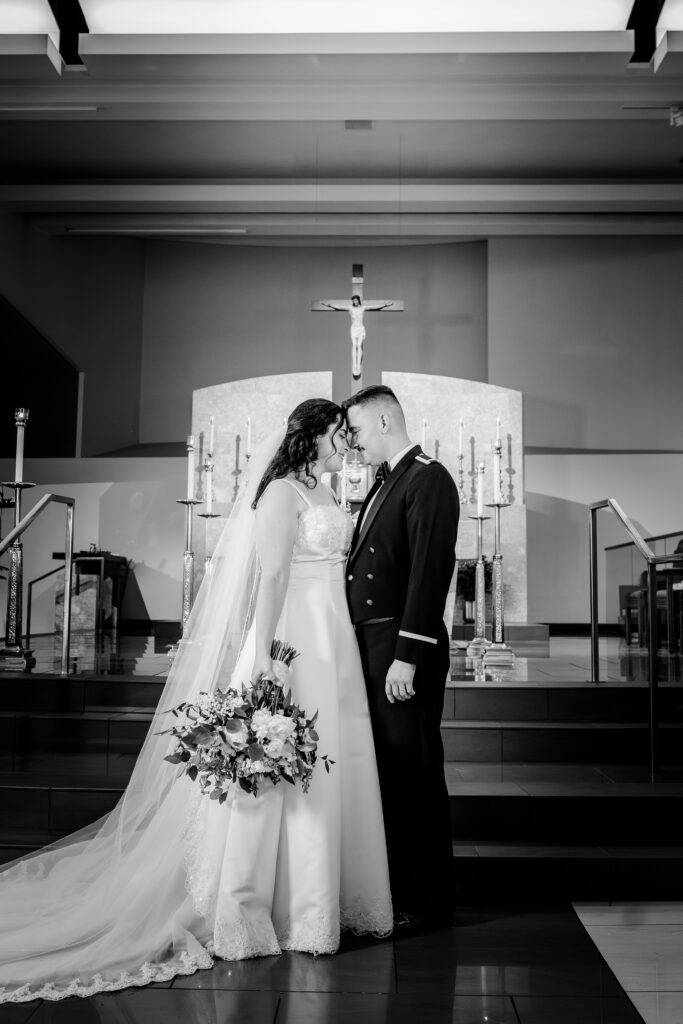 A bride and groom sharing a tender moment forehead to forehead after a wedding at St Philip Catholic Church in Falls Church Virginia