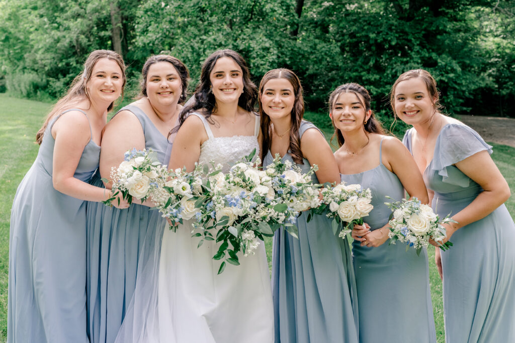 A bride and her bridesmaids leaning in for a photo together during a tented wedding reception at Historic Blenheim in Fairfax, Virginia