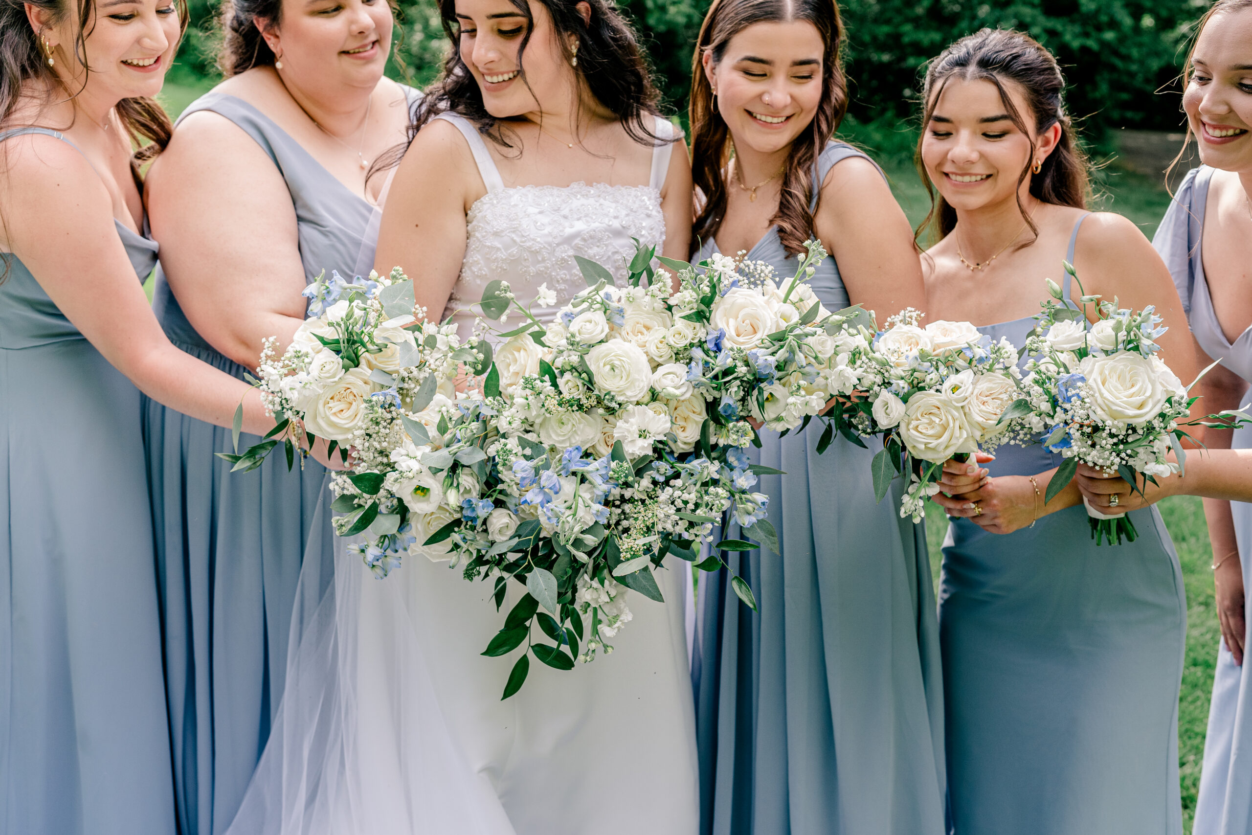 A bride and bridesmaids holding their flowers during a Catholic wedding featured on The Catholic Bridal Collective