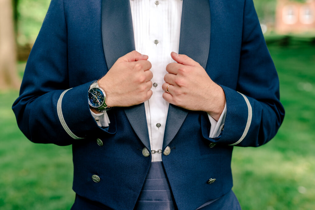 A close up of the groom's details featuring his military uniform and new ring during a tented wedding reception at Historic Blenheim in Fairfax, Virginia