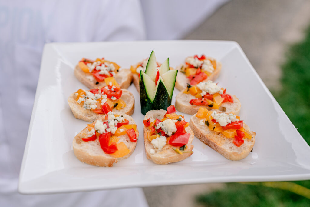 Cocktail hour appetizers on a plate during a tented wedding reception at Historic Blenheim in Fairfax, Virginia