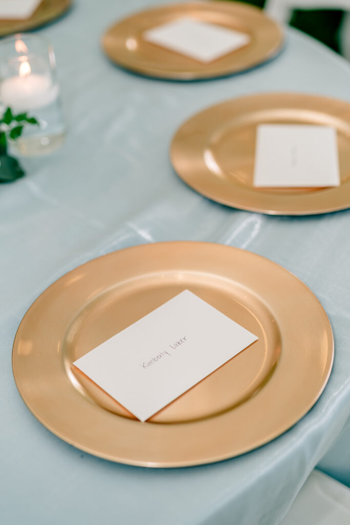 Thank you cards placed on gold chargers during a tented wedding reception at Historic Blenheim in Fairfax, Virginia