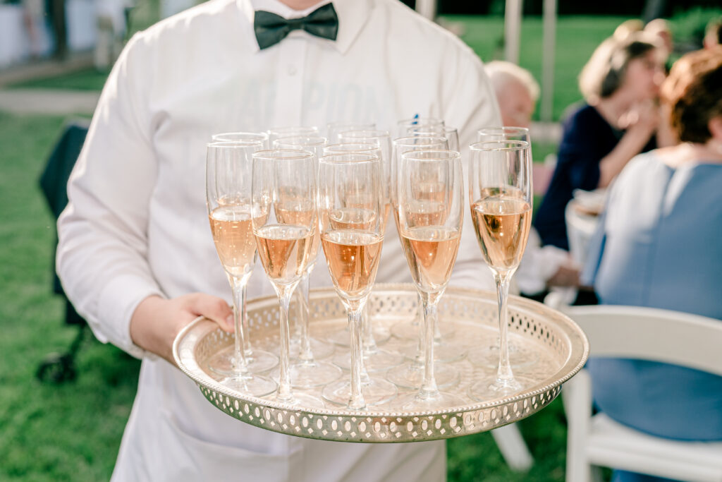 Champagne glasses on a silver serving tray during a tented wedding reception at Historic Blenheim in Fairfax, Virginia