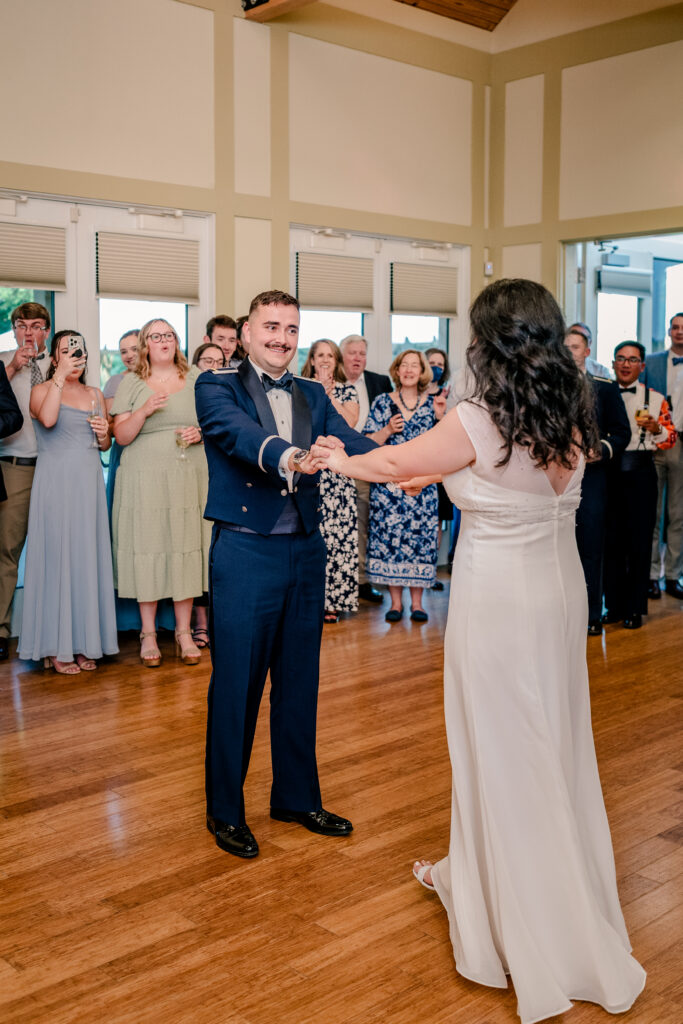 A groom smiles at his bride during their first dance during a tented wedding reception at Historic Blenheim in Fairfax, Virginia