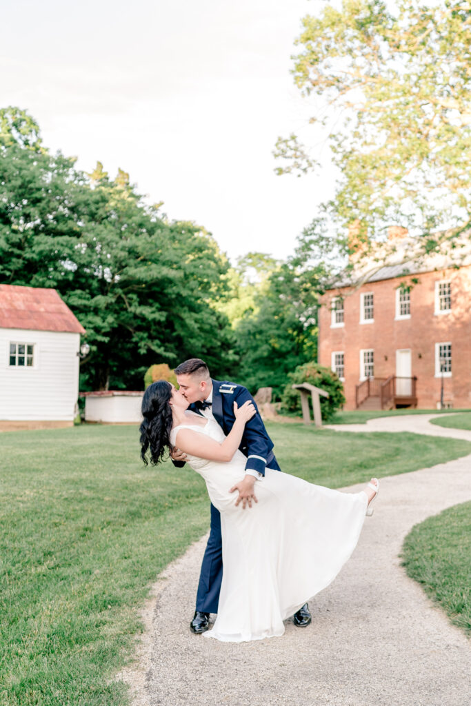 A groom dipping his bride as he gives her a kiss at golden hour during a tented wedding reception at Historic Blenheim in Fairfax, Virginia