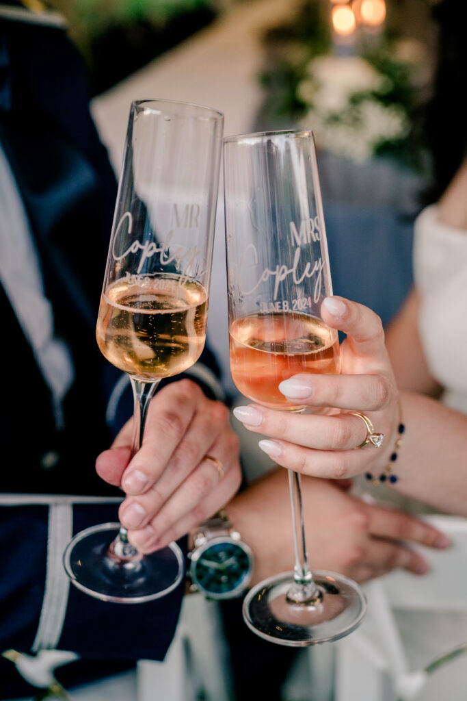 Personalized champagne glasses for the bride and groom during a tented wedding reception at Historic Blenheim in Fairfax, Virginia