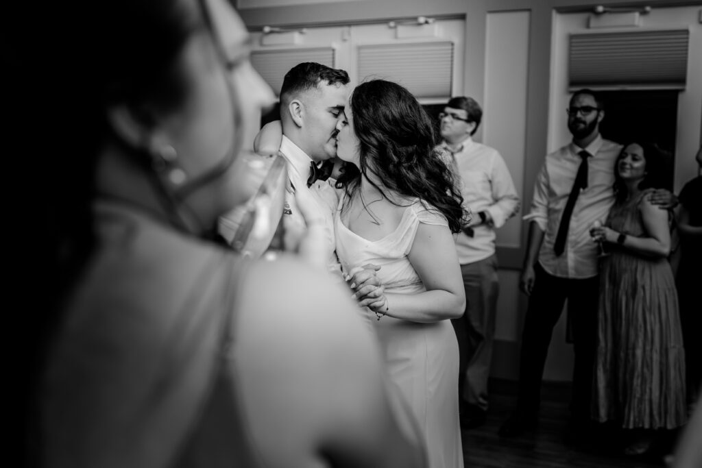 A bride and groom share a kiss on the dance floor during a tented wedding reception at Historic Blenheim in Fairfax, Virginia