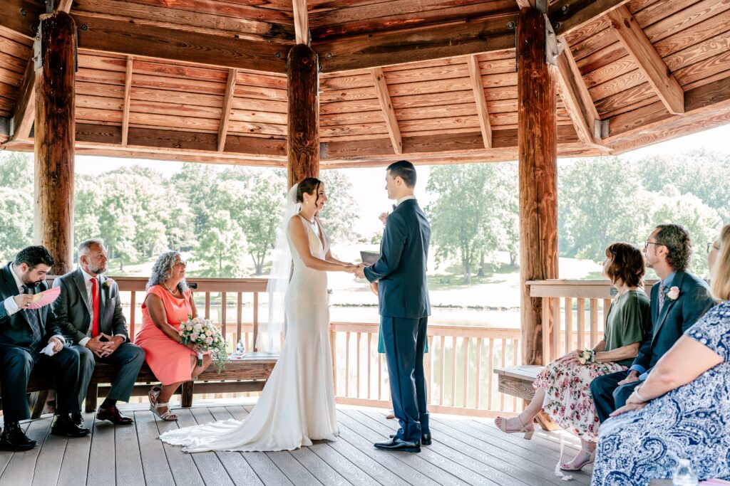 A bride and groom sharing vows under a gazebo