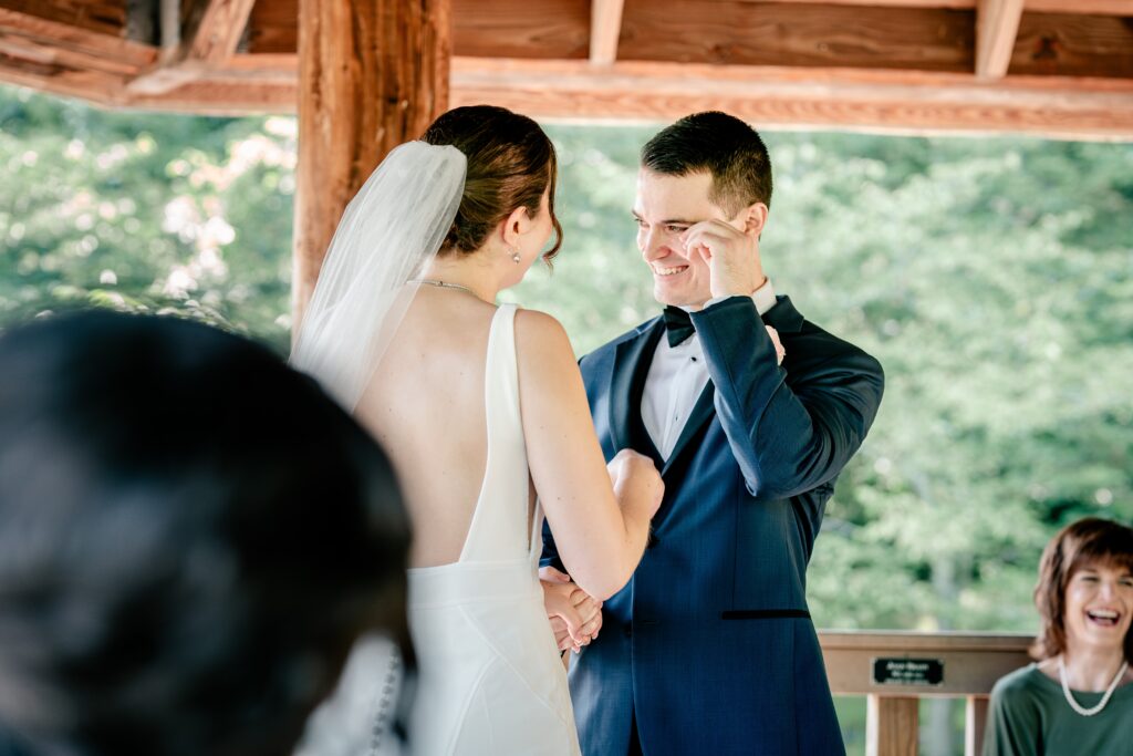 A groom wipes away tears of joy during a micro wedding at Meadowlark Botanical Gardens in Vienna, Virginia