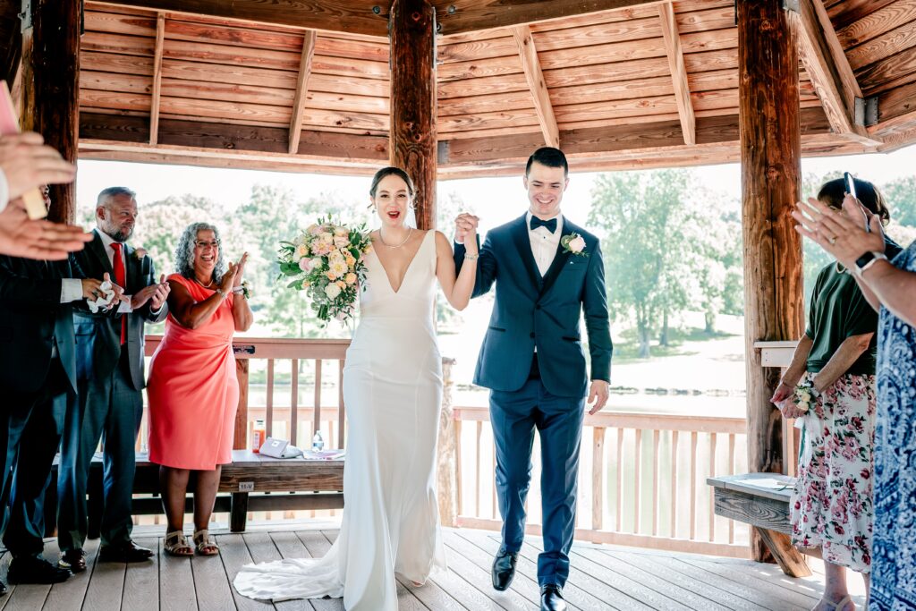 A bride and groom cheer as they exit their micro wedding at Meadowlark Botanical Gardens in Vienna, Virginia