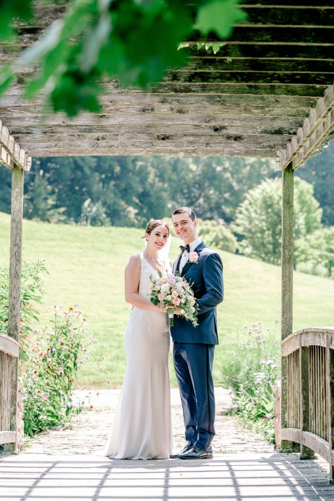 A bride and groom smile for the camera in a classic portrait