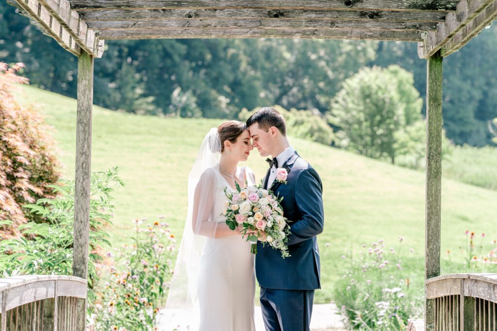 A bride and groom share a tender moment forehead to forehead during a micro wedding at Meadowlark Botanical Gardens in Vienna, Virginia