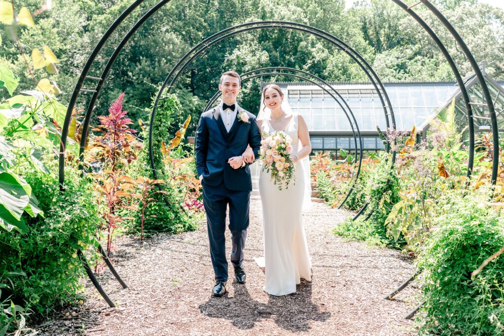 A bride and groom pose for a classic portrait inside a garden during a micro wedding at Meadowlark Botanical Gardens in Vienna, Virginia