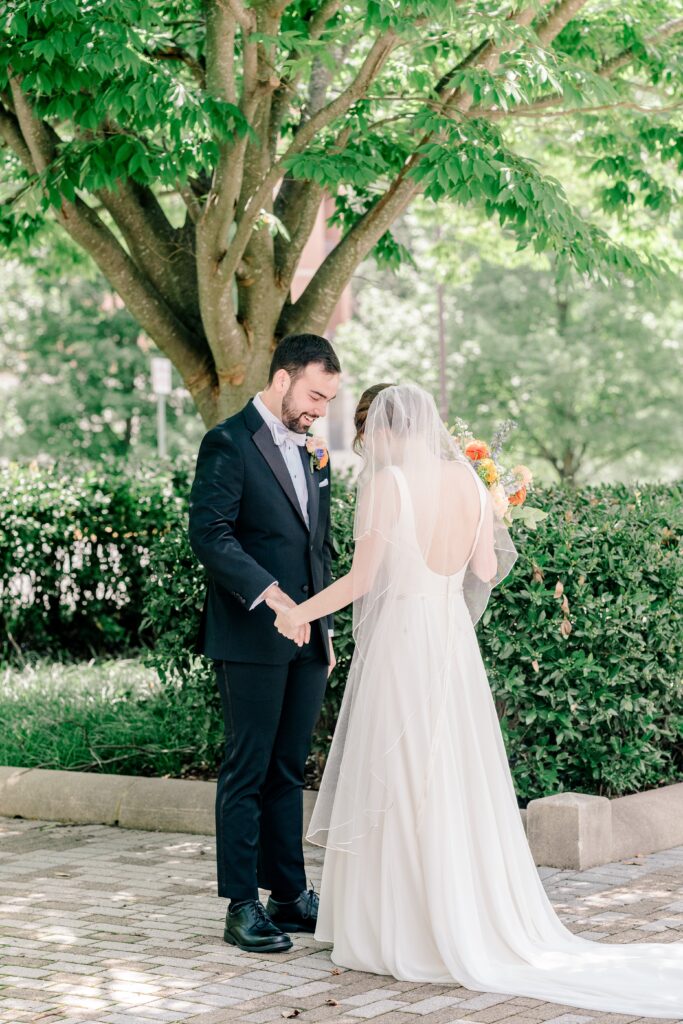 A bride and groom admiring each other during their first look before their Sheraton Reston wedding